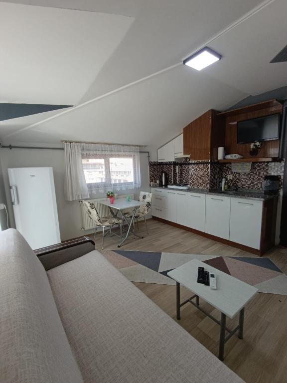 a living room with a couch and a table at Zeytin apart, Daire 10 in Eskiömerler