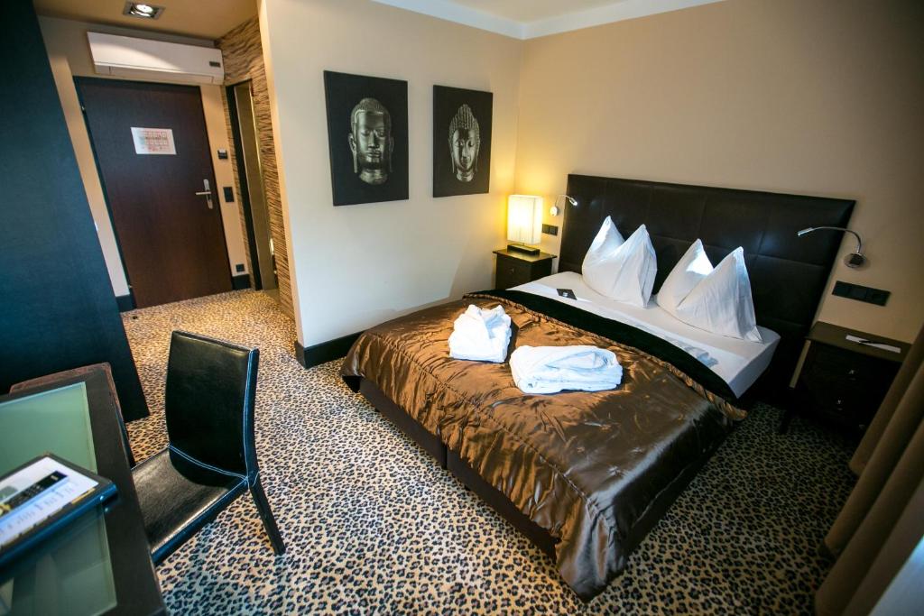 a hotel room with a bed with two towels on it at Hotel Seebrunn am Wallersee in Henndorf am Wallersee