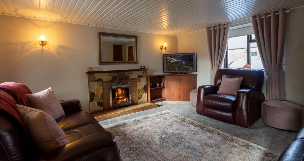 a living room with two chairs and a fireplace at Killard Farm in Bellaghy