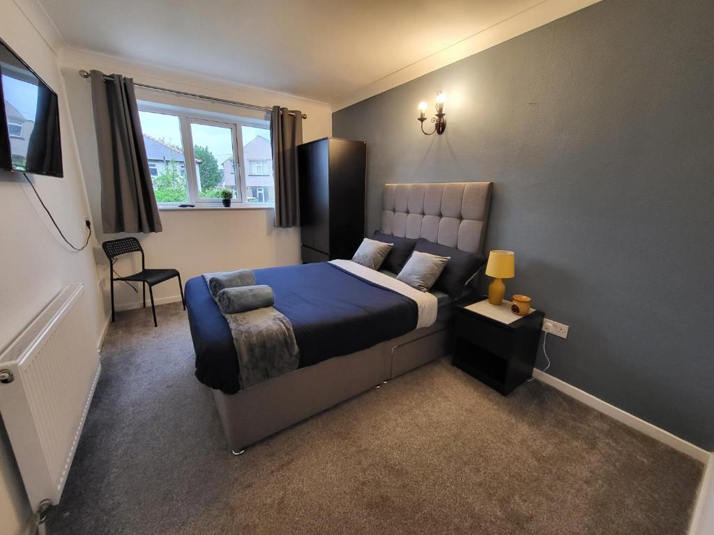 a bedroom with a king sized bed with a blue blanket at Family friendly 3-bed home free parking on site in Huddersfield