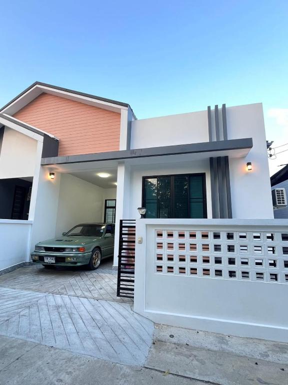 a car parked in front of a house at The Stay Inn in Kampong Rusamileh
