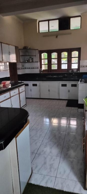a large kitchen with white cabinets and windows at Luxury bungalow in Patiāla
