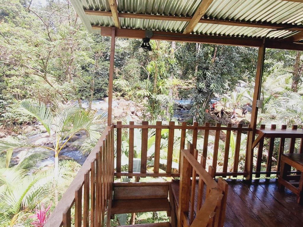a wooden porch with a view of a waterfall at Cabins river blue in Rio Celeste