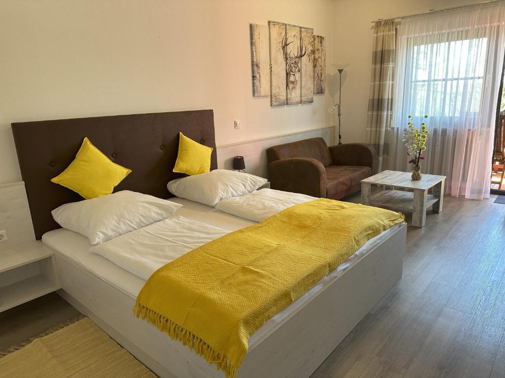ein Schlafzimmer mit einem Bett mit einer gelben Decke darauf in der Unterkunft Ferienwohnung Thermenauszeit - mit Balkon und Bademantelgang in Bad Griesbach