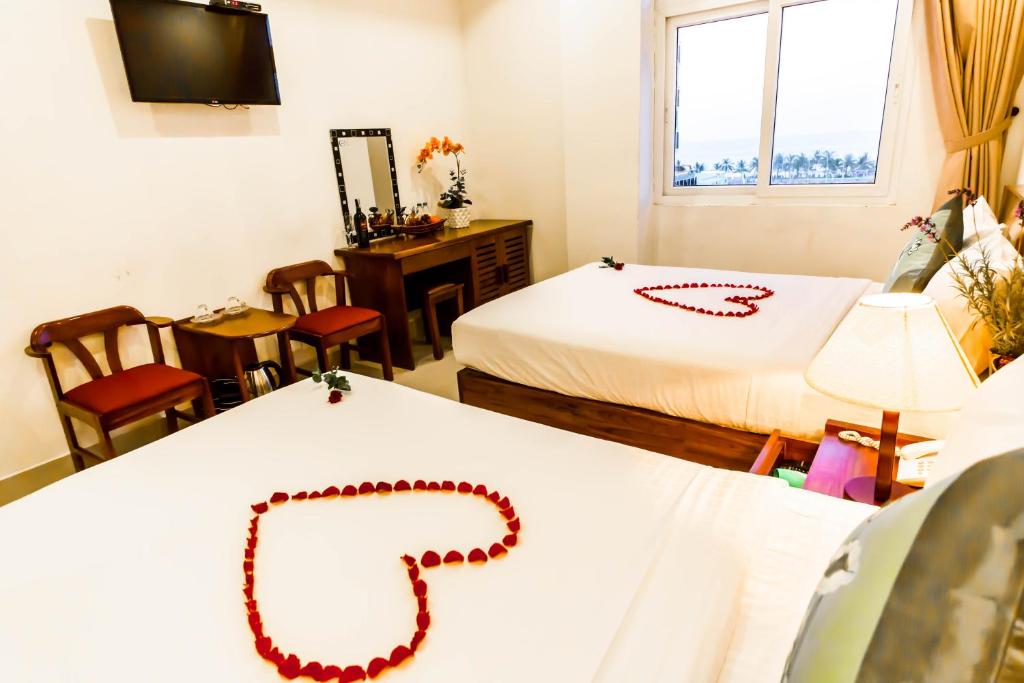 a room with two beds and a necklace on a table at Kiên Cường 2 Hotel in Da Nang