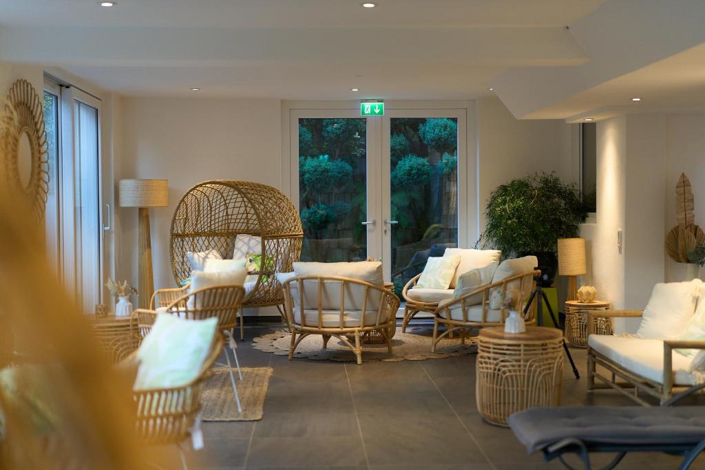 a living room with wicker chairs and a table at Kirchers Park & Wellnesshotel Kaiserstuhl in Endingen