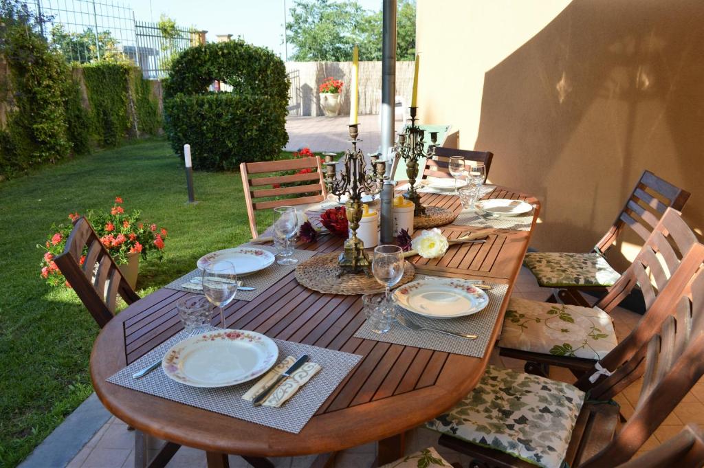 una mesa de madera con platos y copas de vino. en La Reggia dell'Etna, en Zafferana Etnea