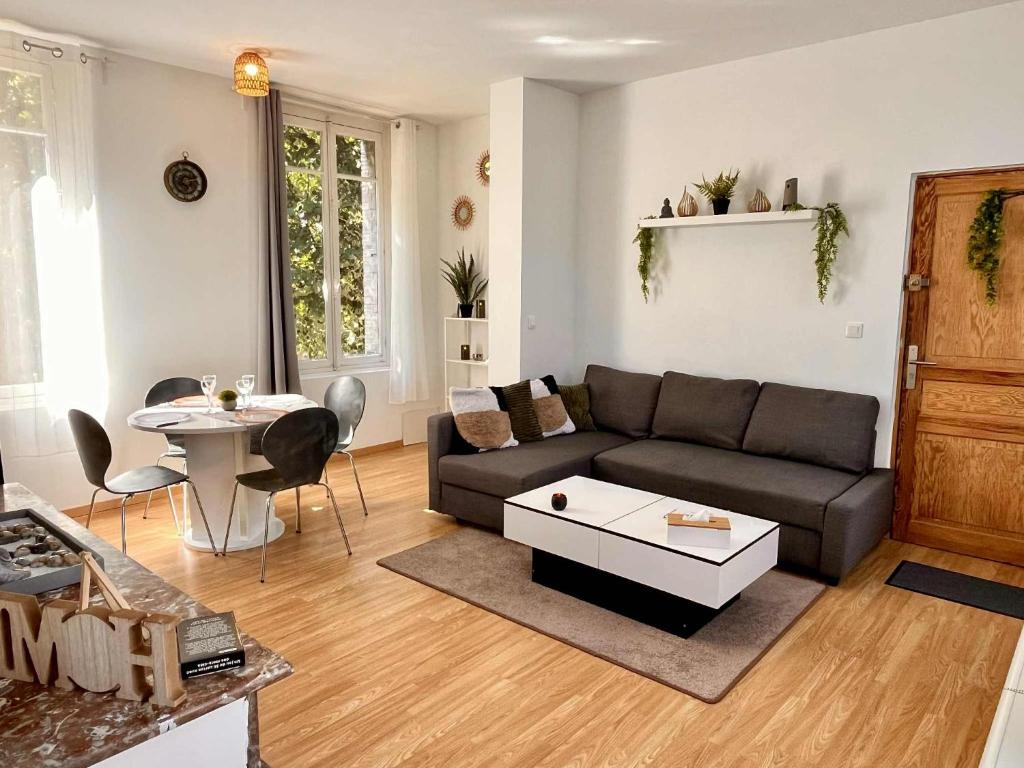 a living room with a couch and a table at L'Orée du Jardin T3 parking in Rouen