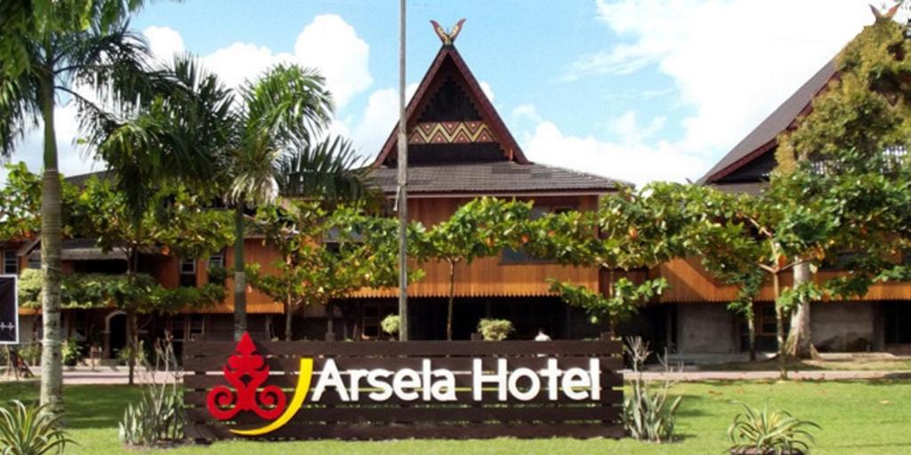 ein Hotel mit einem Schild vor einem Gebäude in der Unterkunft Arsela Hotel Pangkalan Bun in Pangkalan Bun