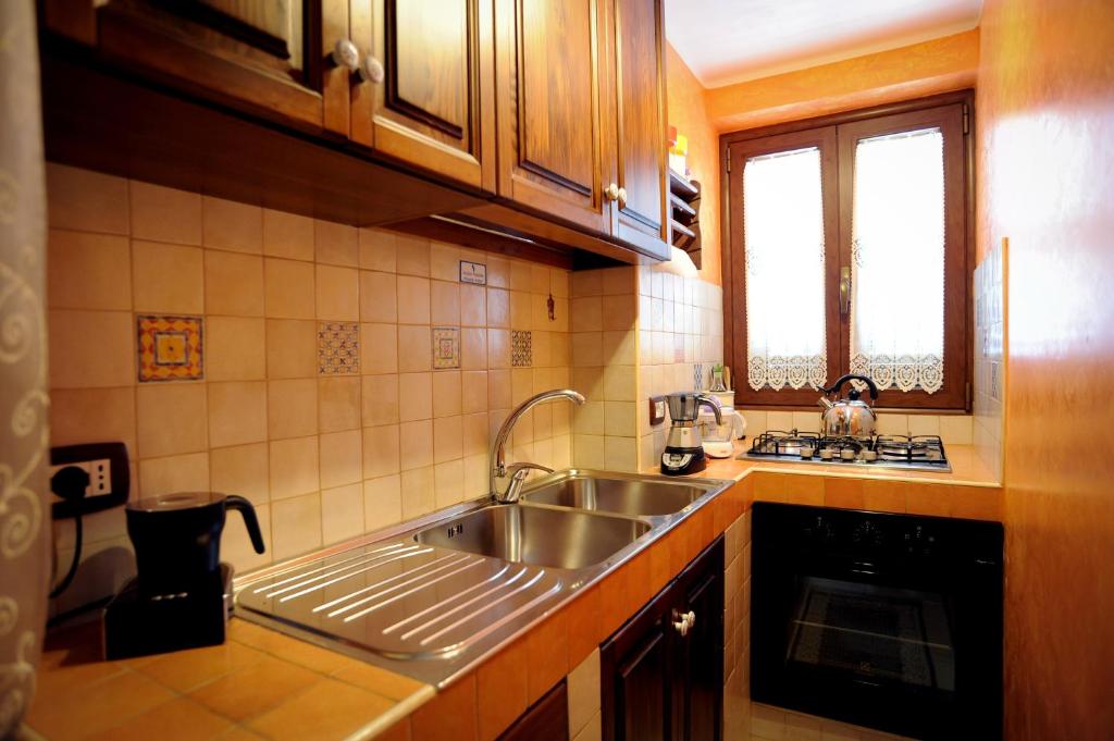 una cucina con lavandino in acciaio inossidabile e finestra di Trullo Di Tagaro a Locorotondo