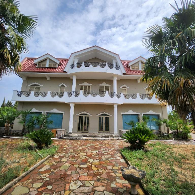 a large white house with a red roof at REZIDENCA ARBNORE - Tre Horizonte in Koplik