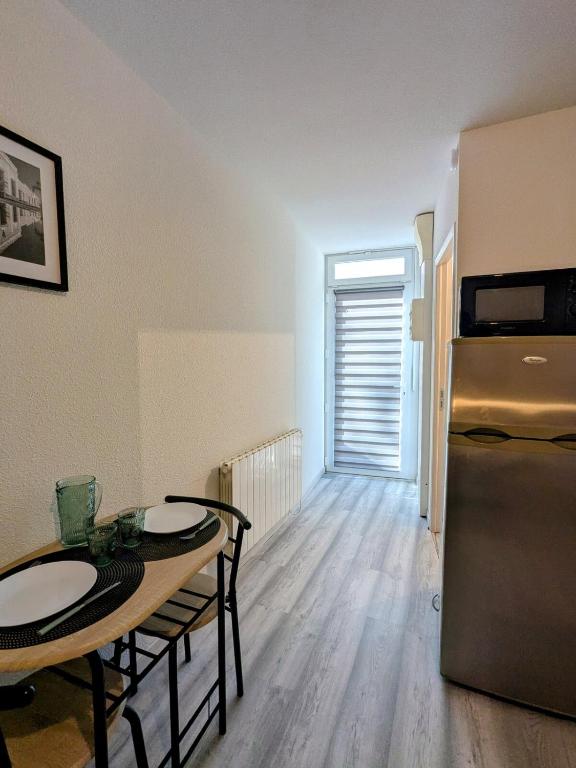 un salon avec une table et un réfrigérateur dans l'établissement Studio centre ville proche gare, à Roanne