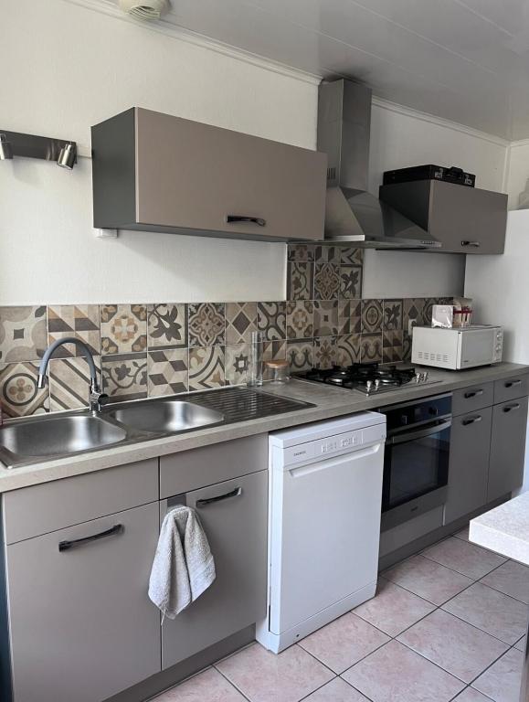 a kitchen with a sink and a stove at Maison de ville in Cognac