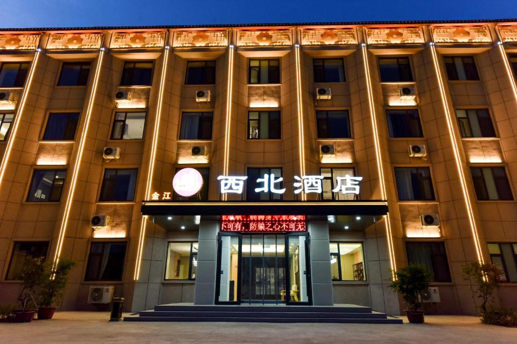 Un edificio con un cartel en el frente. en 金江西北大酒店, en Dunhuang