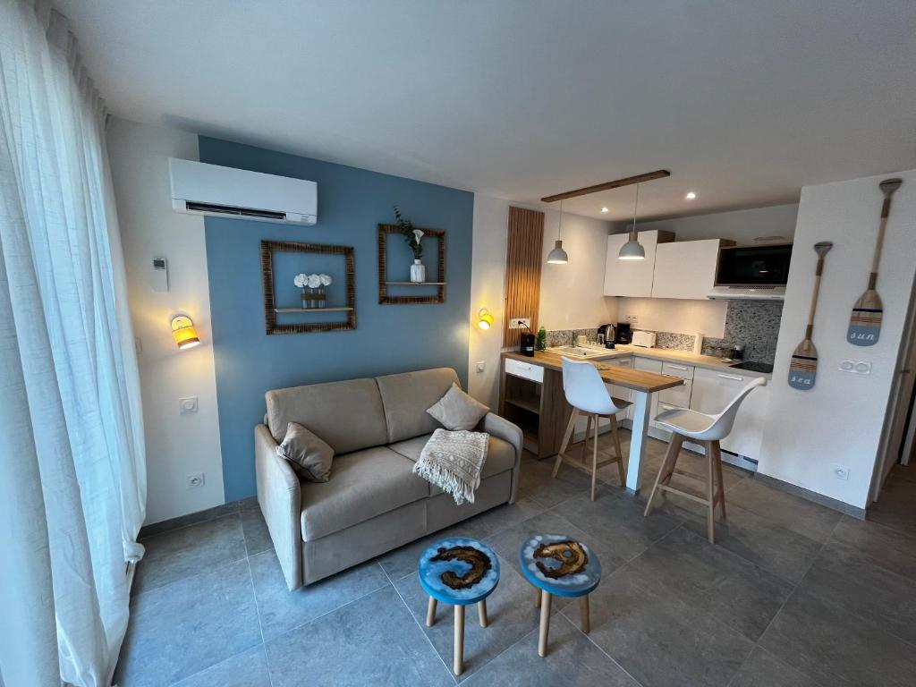 ein Wohnzimmer mit Couch und Küche in der Unterkunft La Bulle Marine in La Grande-Motte