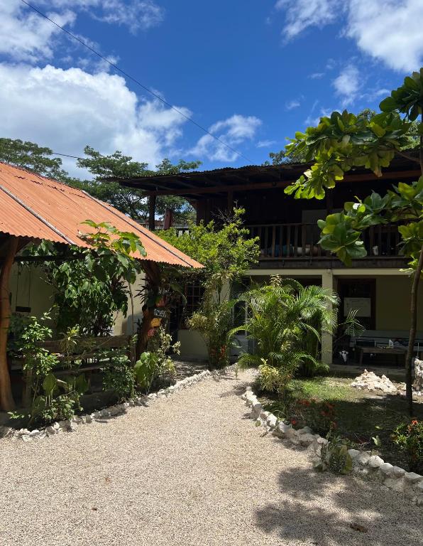 a house with an orange roof and some trees at Woodstock Hostel in Sámara