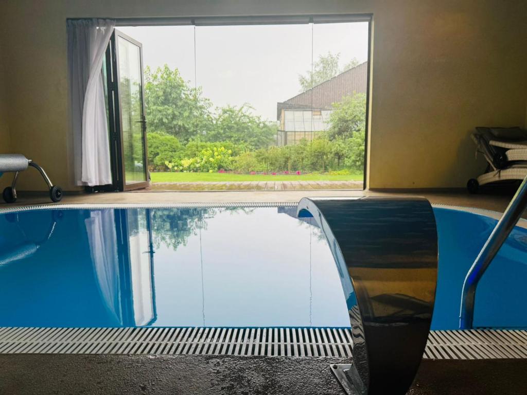 a swimming pool in a room with a large window at Family apartment with pool & garden view in Mārupe