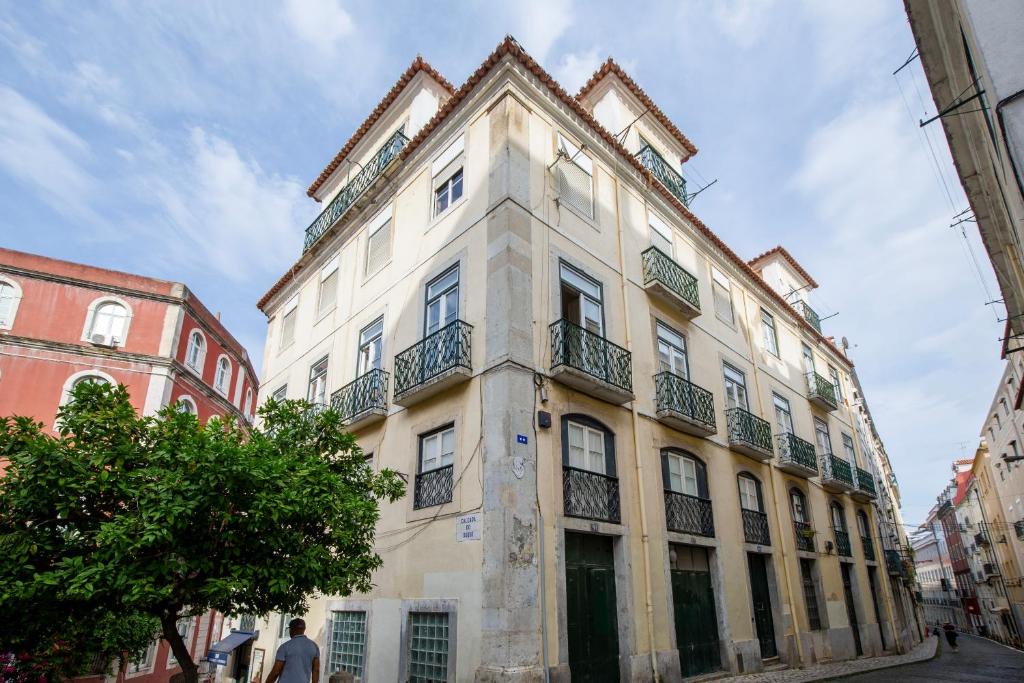 a tall white building with balconies on a street at Condessa Vintage Apt Chiado in Lisbon