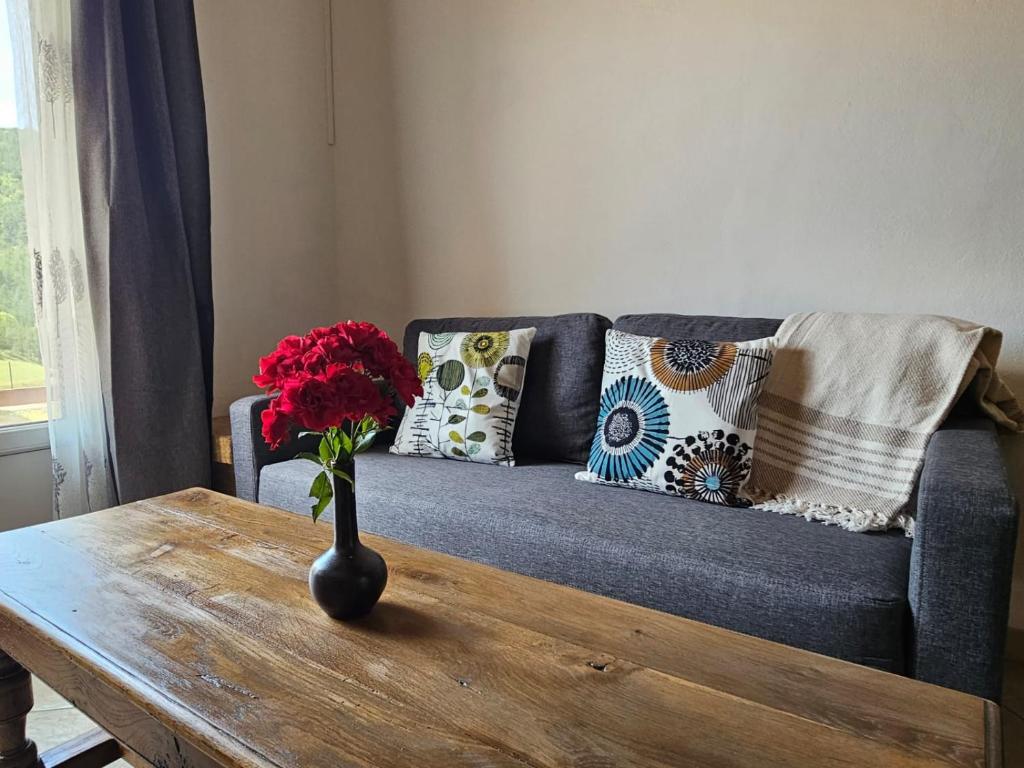 un jarrón con una flor sobre una mesa de madera en Casa De Férias, en Volvent
