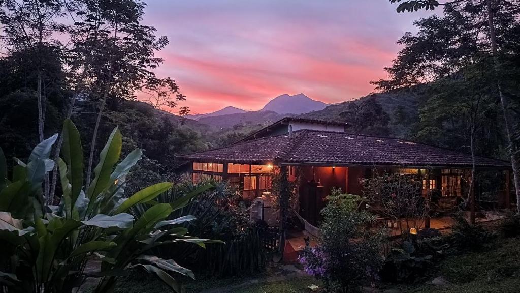 a house with a mountain in the background at Casa Encantada in Paraty