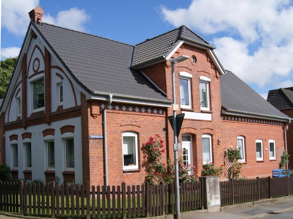 ein rotes Backsteinhaus mit schwarzem Dach in der Unterkunft Ferienwohnung Ilsebill in Husum