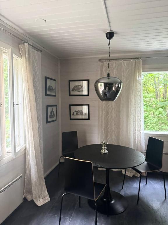 a dining room with a black table and chairs at The Red Residence, Savonlinna Centre in Savonlinna