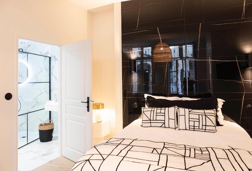 une chambre avec un lit et un mur noir dans l'établissement Studio élégant, à La Rochelle