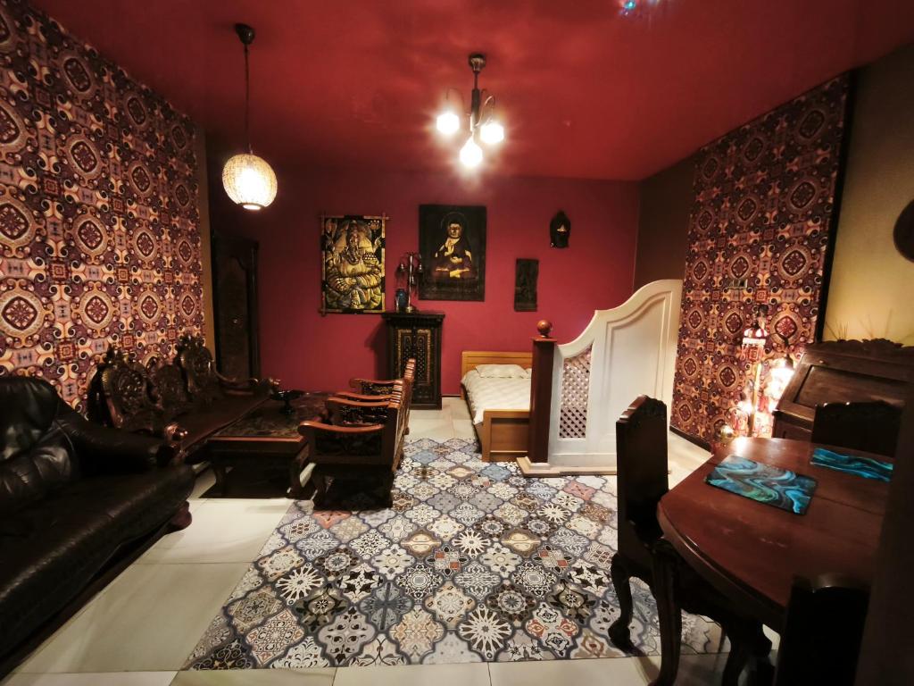 a living room with red walls and a couch and a fireplace at Sekret Maharadży - The Maharaja's Secret in Częstochowa