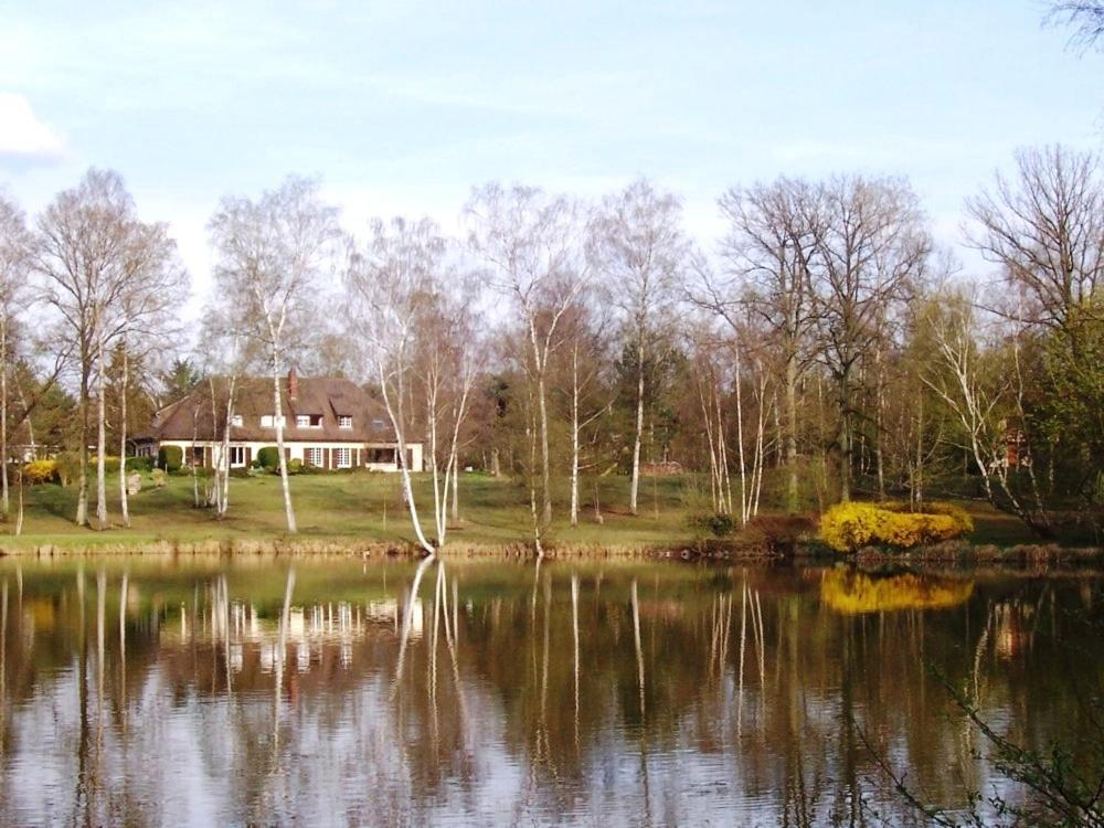 a house sitting next to a large lake at Résidence Clairbois, Chambres d'Hôtes in Fère-en-Tardenois