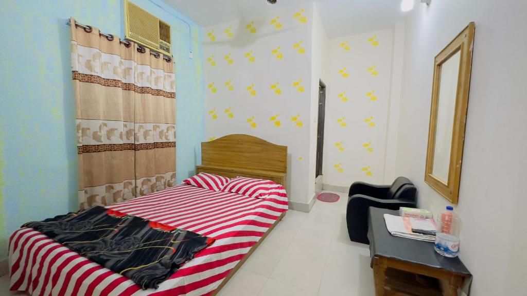 a bedroom with a bed with a red and white stripes at Hotel Rongdhanu Residential in Dhaka