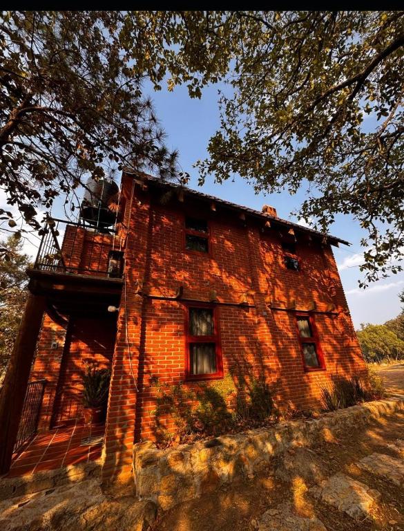 a brick building with a balcony on top of it at Cabaña en El Zembo, Huasca de Ocampo in Huasca de Ocampo