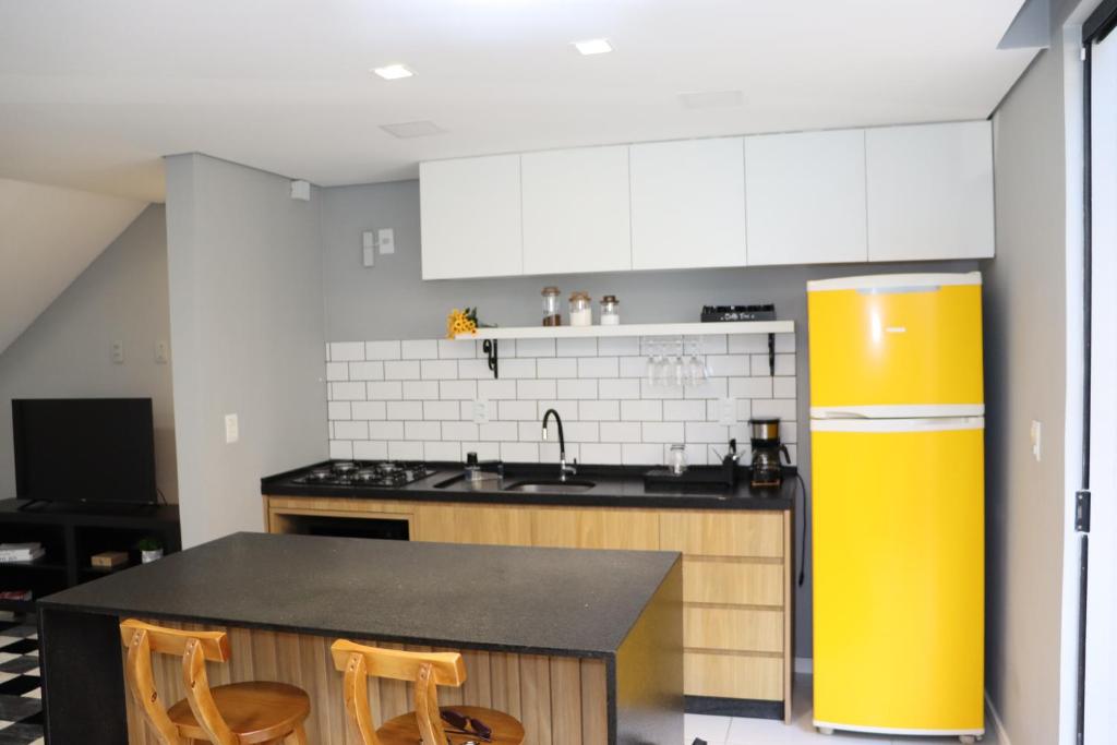 a kitchen with a counter and a yellow refrigerator at A 700m da Praia e do Shopping, Liberdade, Churrasq, Garagem e Estaciona Livre in Balneário Camboriú