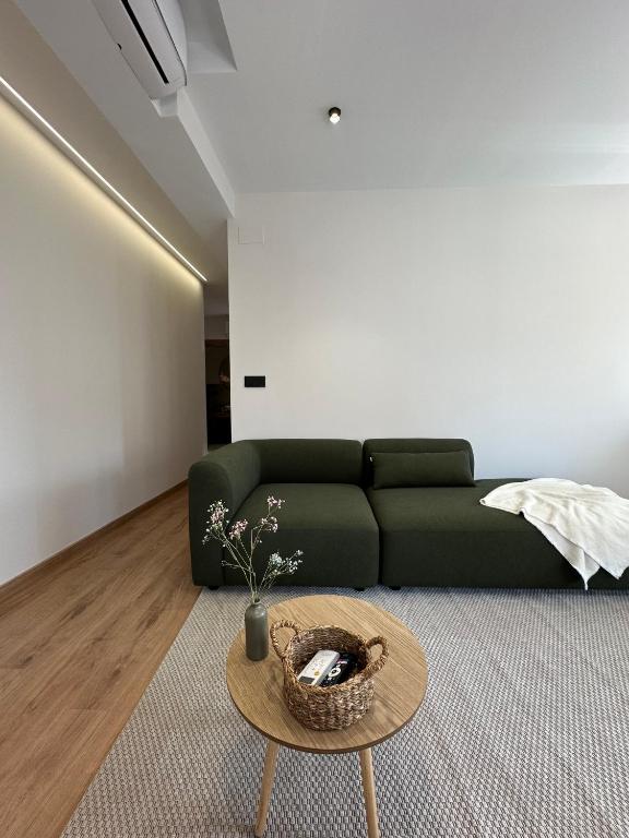 Una sala de estar con un sofá verde y una mesa. en Lemos Agra, en Monforte de Lemos