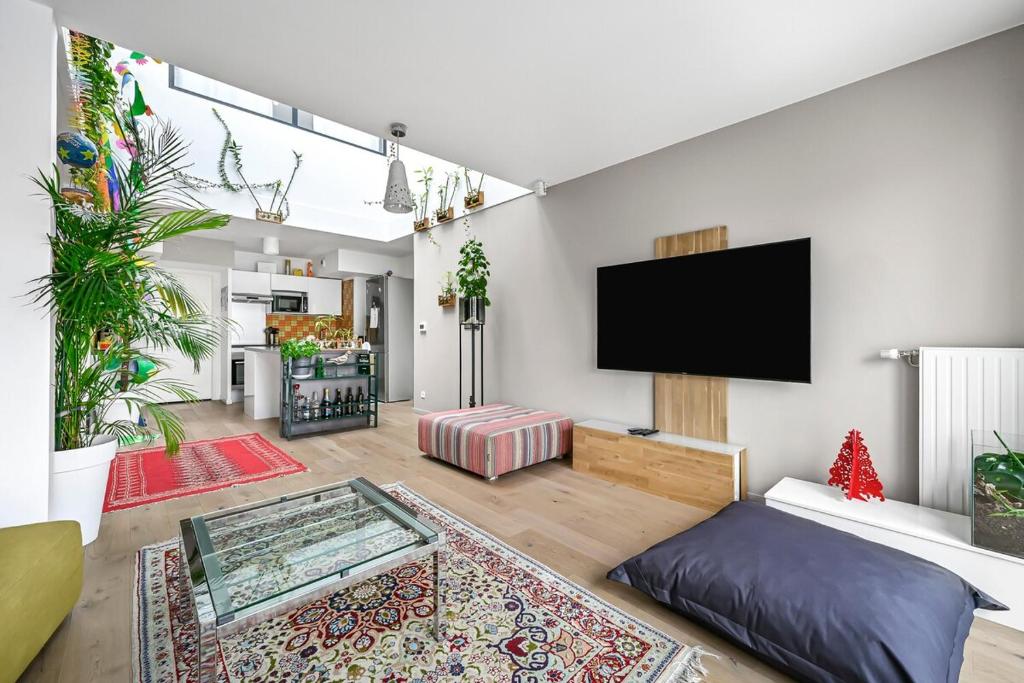 a living room with a flat screen tv on a wall at Le Nina - Duplex - Terrasse - 3 BDR - Proche Paris in Bois-Colombes