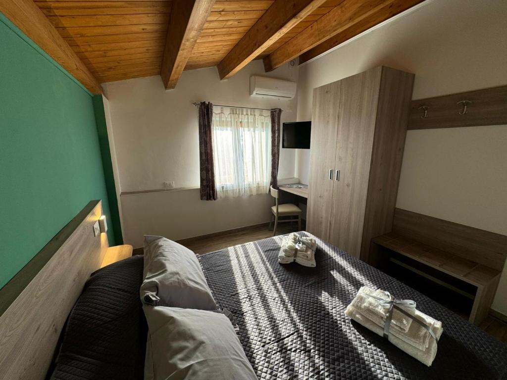 a bedroom with a bed with two towels on it at Come a Casa in Santa Maria del Cedro
