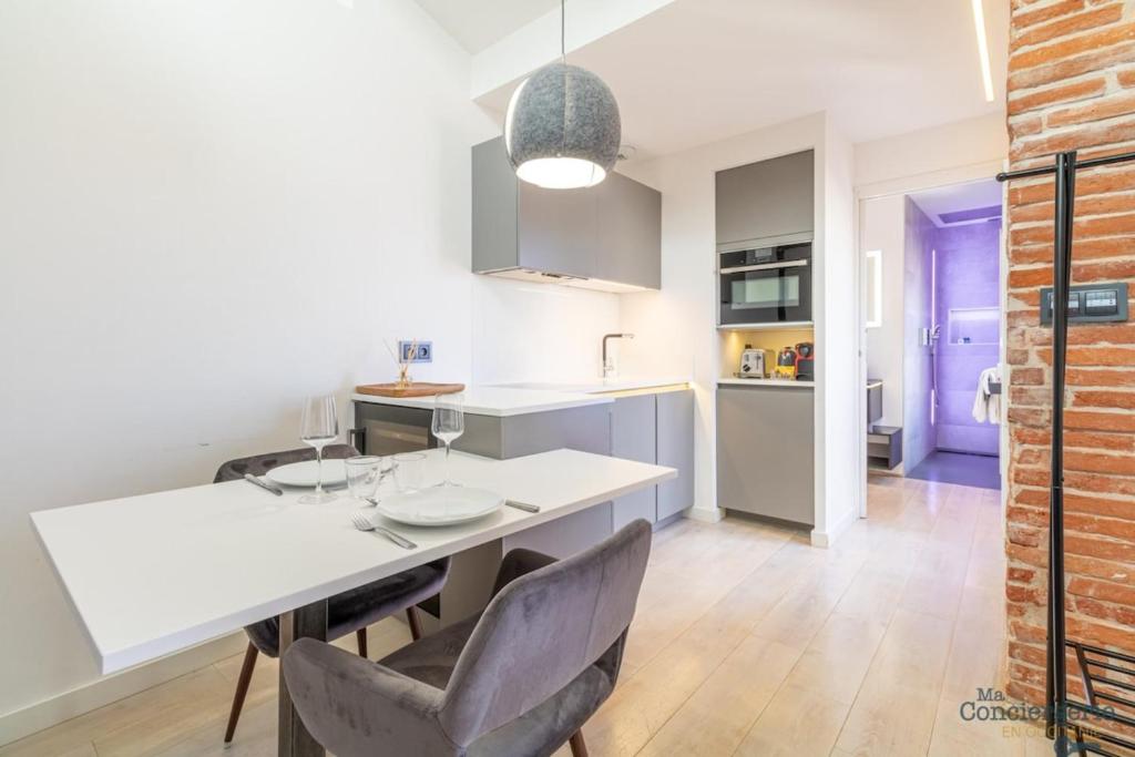 une cuisine et une salle à manger avec une table et des chaises blanches dans l'établissement Lorraine - Vue St-Sernin - Hypercentre - Capitole, à Toulouse