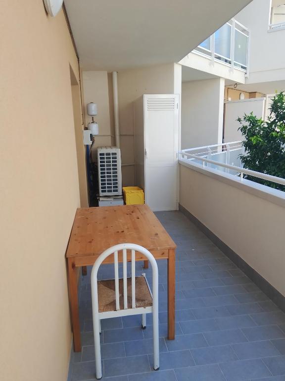 a wooden table and a white chair in a room at Vacanze MARE Vasto in Vasto