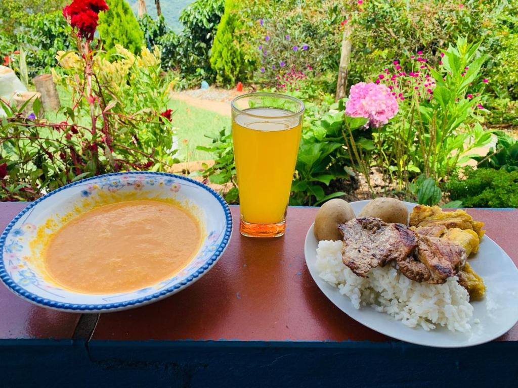 a table with a bowl of food and a glass of orange juice at Cabaña el sol in Titiribí