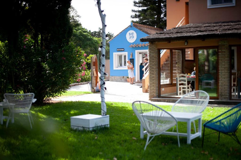 a group of chairs sitting in the grass in a yard at Nexo Surf House in El Palmar