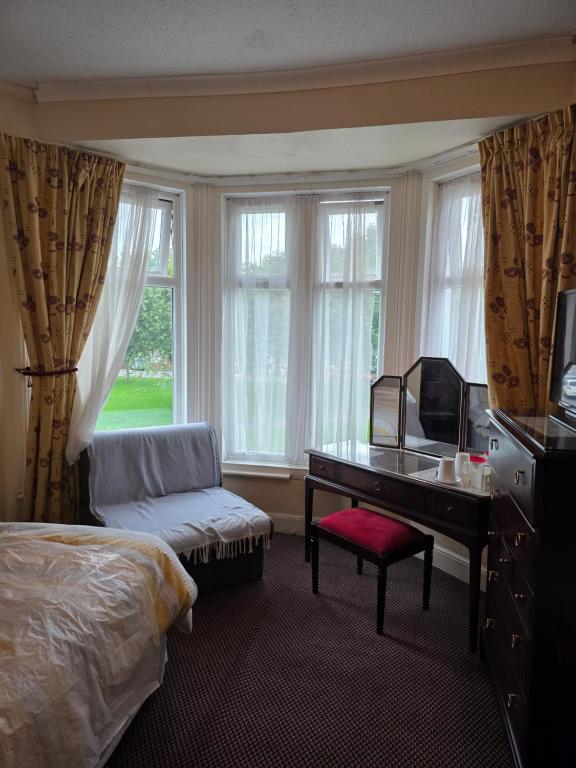 Una habitación de hotel con una cama, un escritorio y un televisor. en Marina guest house, en Great Yarmouth