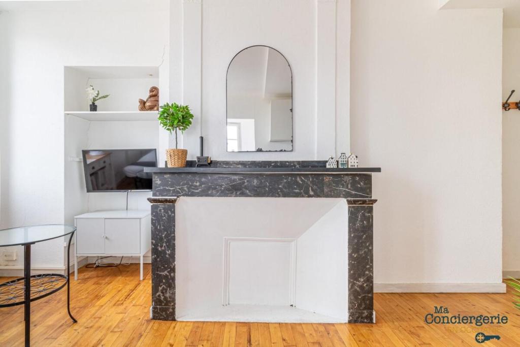 - un salon avec un miroir au-dessus d'une cheminée dans l'établissement Parga 41 - 500 mètres du Capitole - Hypercentre Tlse, à Toulouse