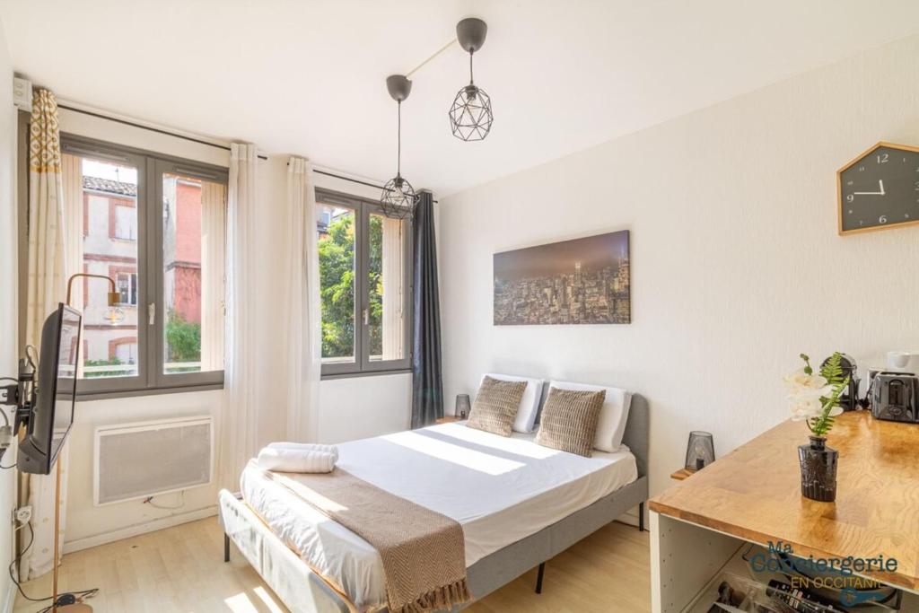 une chambre avec un lit, un bureau et des fenêtres dans l'établissement Heliot - Hypercentre - Proche du métro, à Toulouse