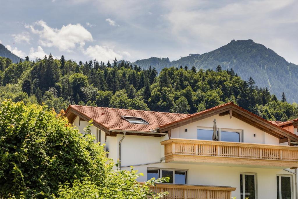 a house with a balcony with mountains in the background at Das Gipfelglück in Berchtesgaden