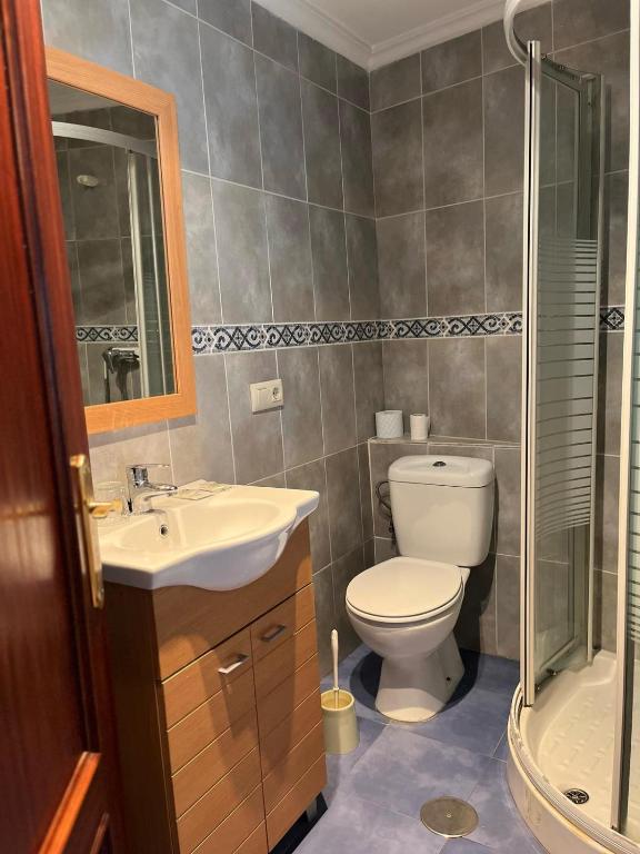 a bathroom with a toilet and a sink and a shower at Pensión San Francisco in Muñera