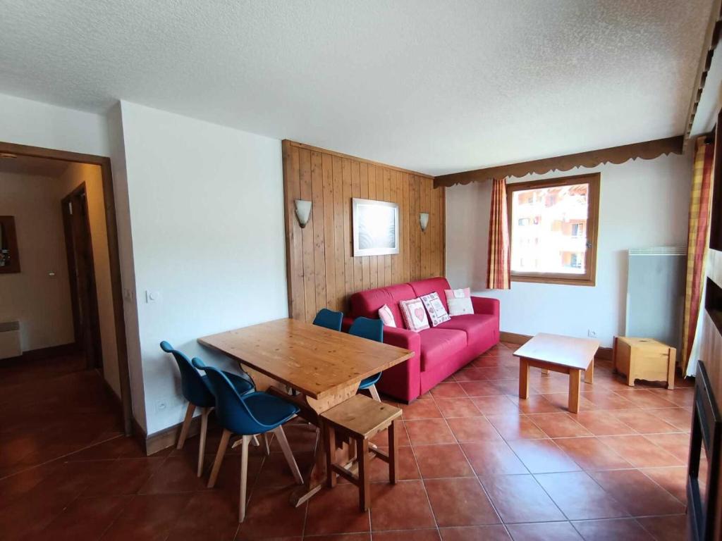 a living room with a pink couch and a table at Résidence Les Airelles - appartement plein sud, parking couvert - 50m des pistes MAE-8394 in Montgenèvre