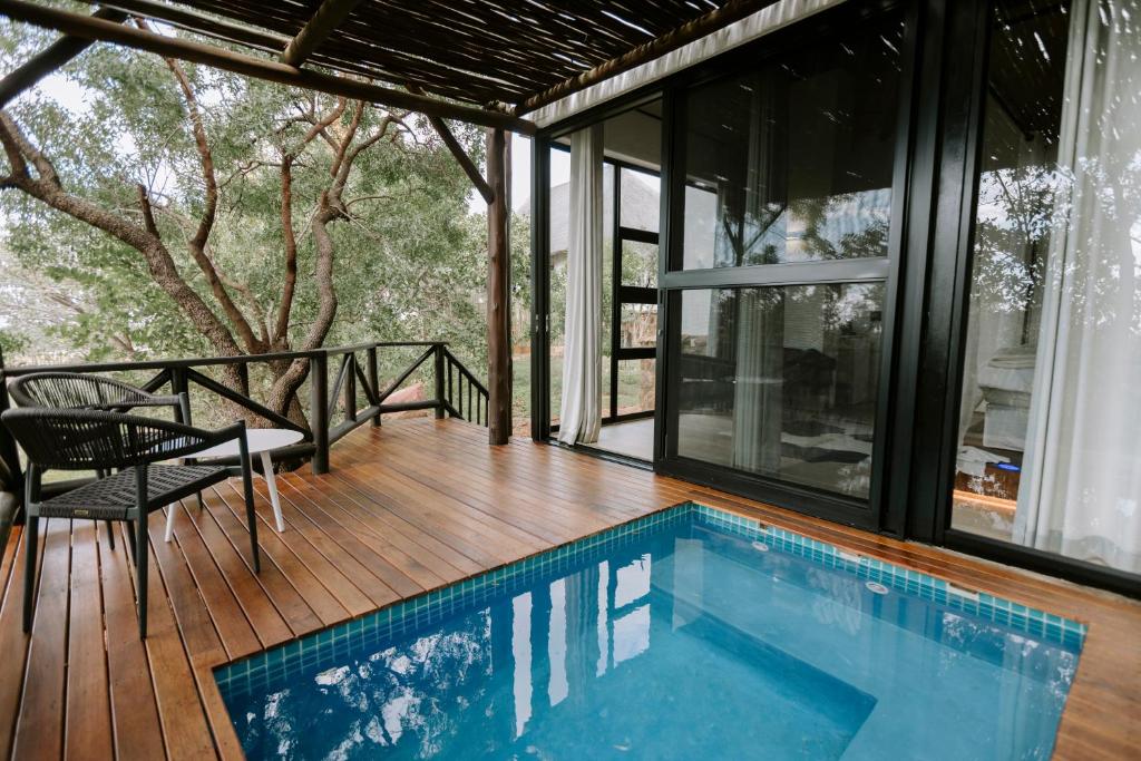 a house with a swimming pool on a wooden deck at Rhino Plains in Welgevonden Game Reserve