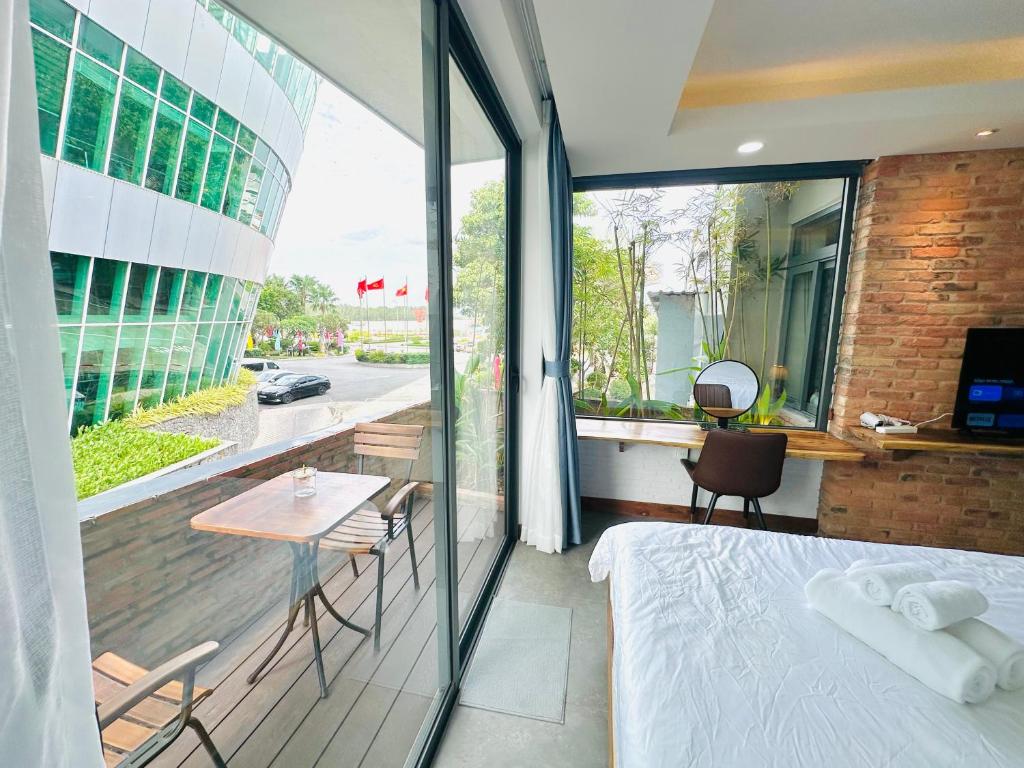 a bedroom with a bed and a table and a balcony at 202MSNK Luxe Studio w Balcony & Kitchen in Can Tho