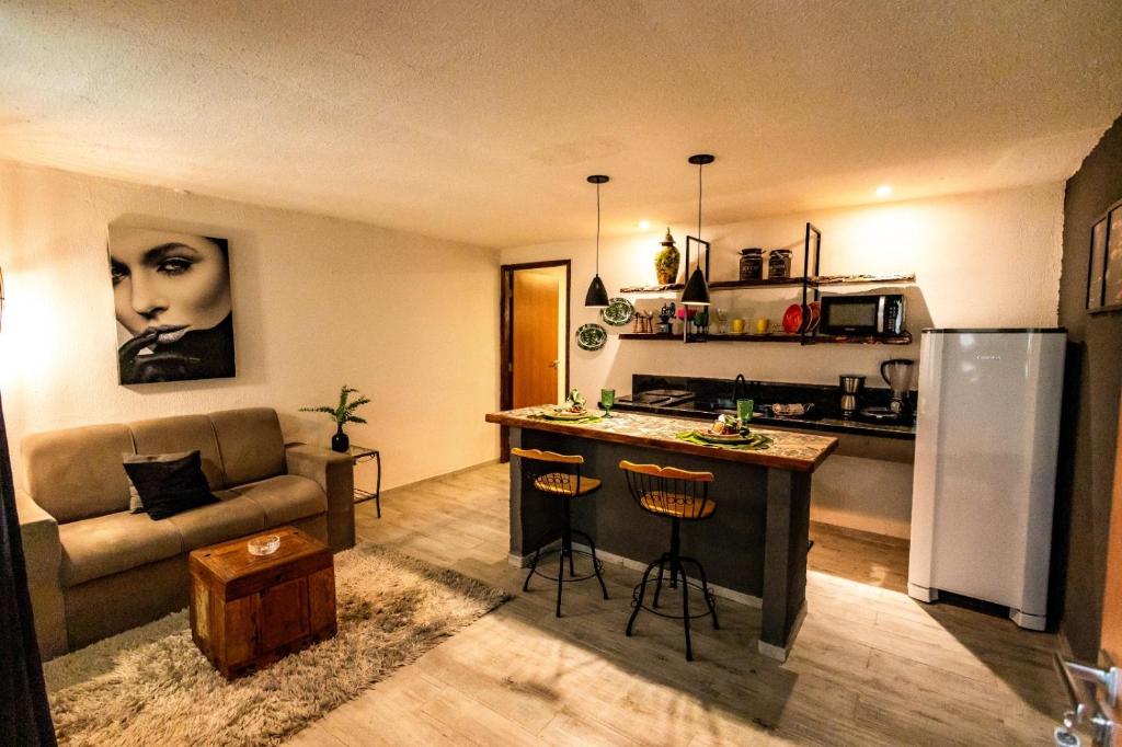 a kitchen and living room with a couch and a table at Apartamento Villa Siena Condomínio À Beira Mar próximo ao Aeroporto in Salvador