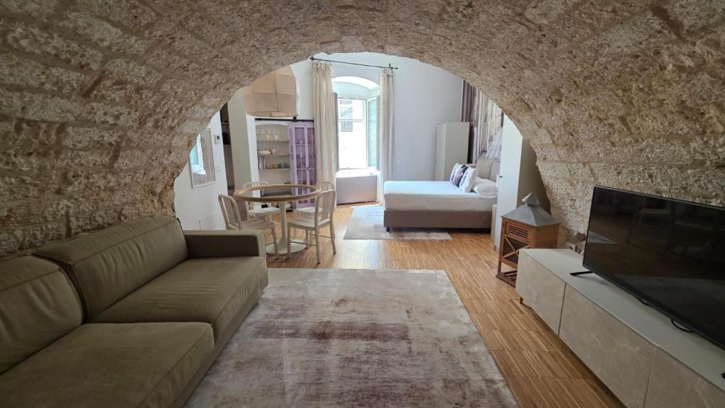 a living room with a couch and a tv at La Caverna - Bari Vecchia, Fronte Mare in Bari