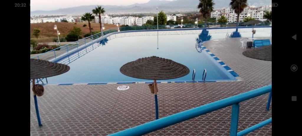 a swimming pool with two umbrellas in front of it at Résidence de luxe cabo dream 2 chambre salon in Cabo Negro